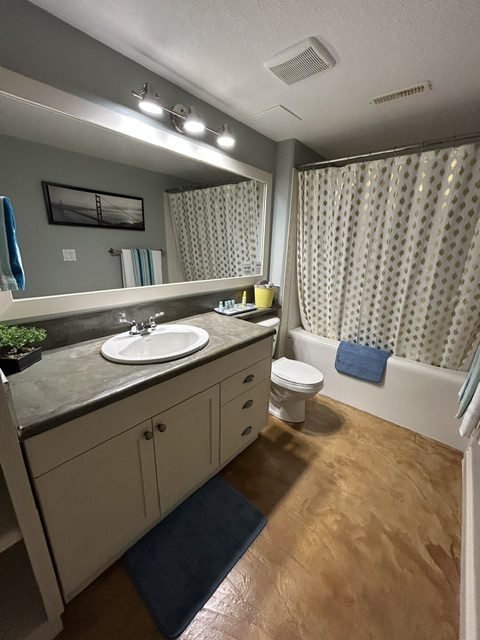 Clean bathroom with vanity, large mirror and tub