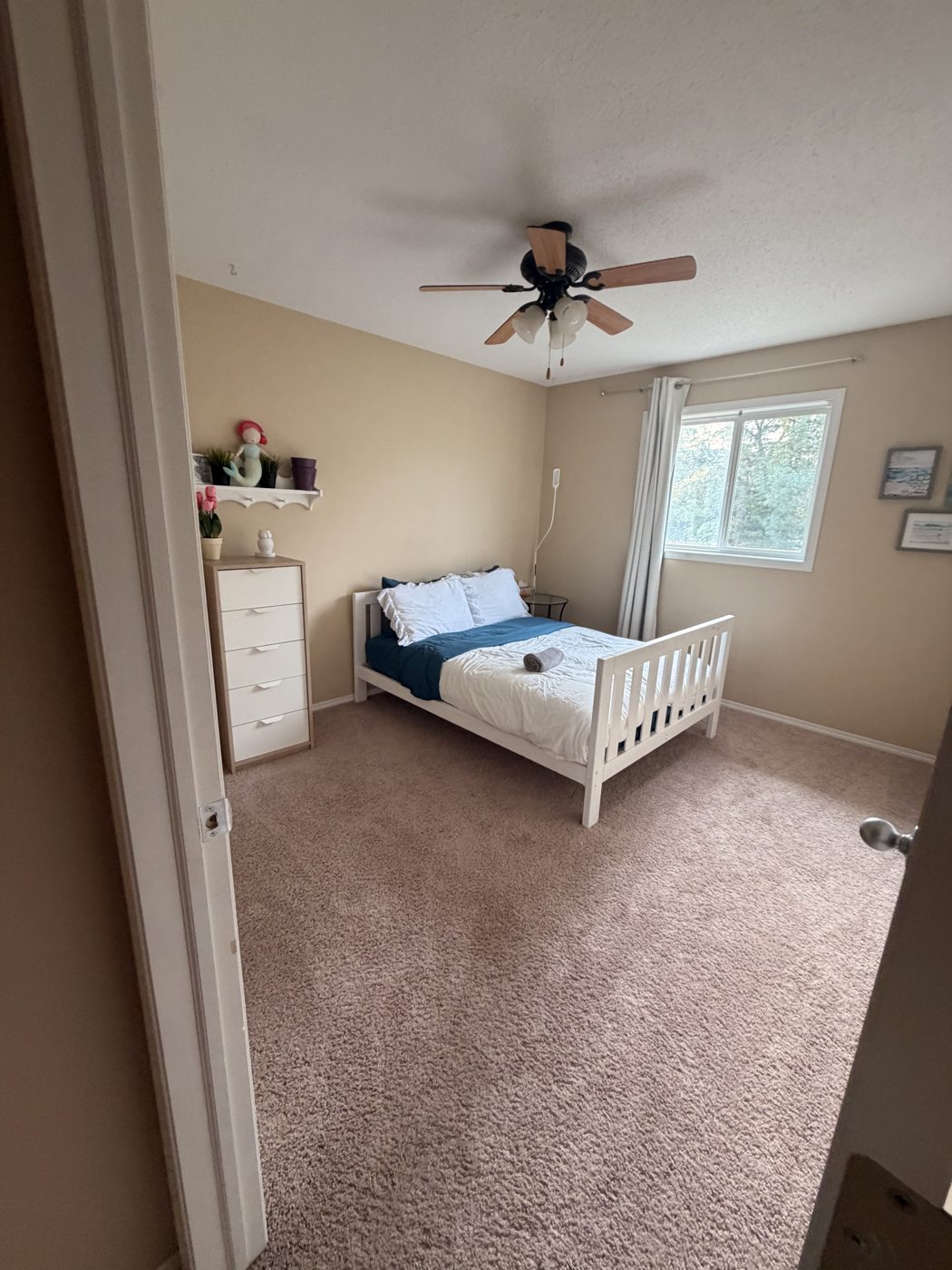 Freshly cleaned bedroom with made bed and vacuumed carpet