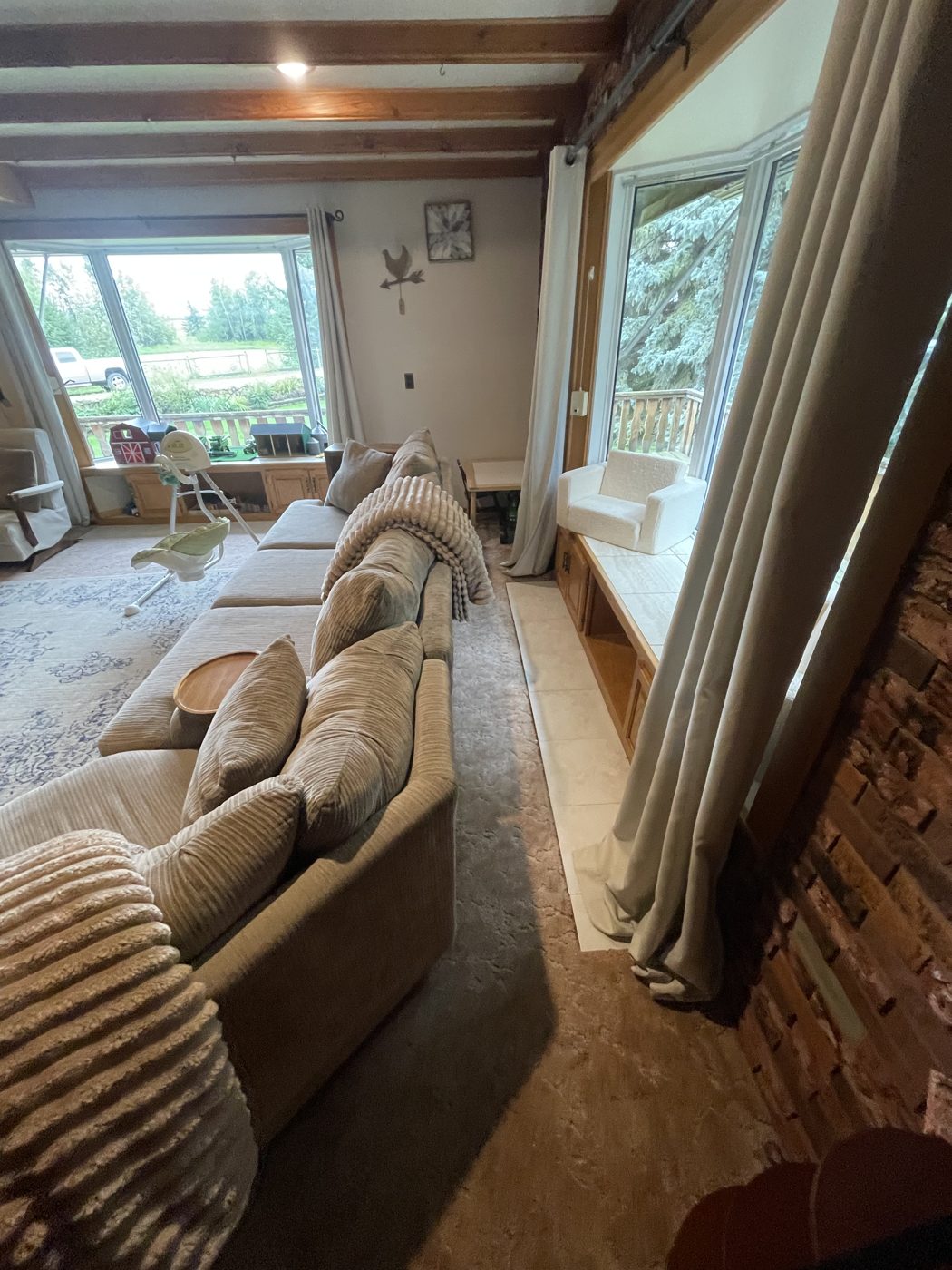Bright, tidy living room with sectional sofa and freshly cleaned floors