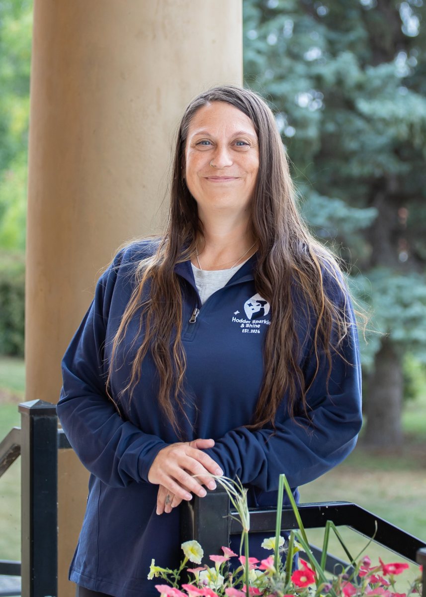 Marsha, Hodder Sparkle & Shine cleaner, smiling in her HSS quarter-zip